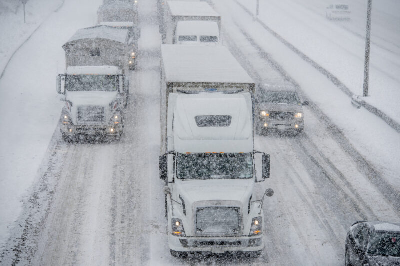 Semi truck traffic on Interstate 5 during a winter snow and freezing rain storm