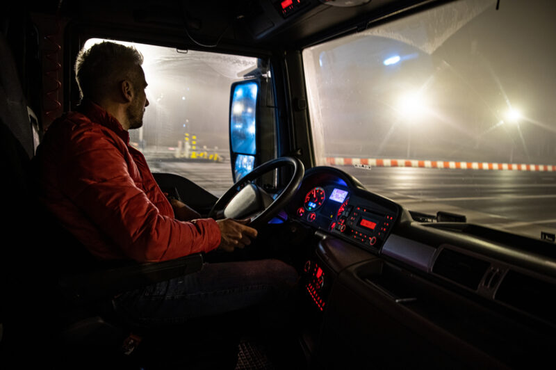 Picture of driver at wheel of truck.