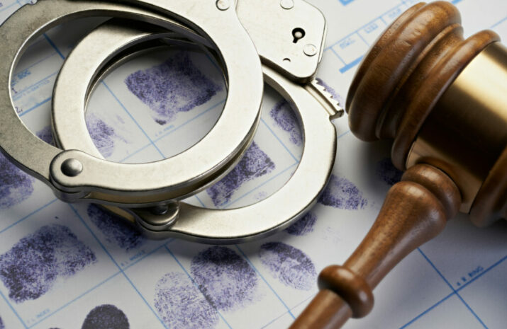 Gavel and handcuffs on fingerprints: Arrest crime concept