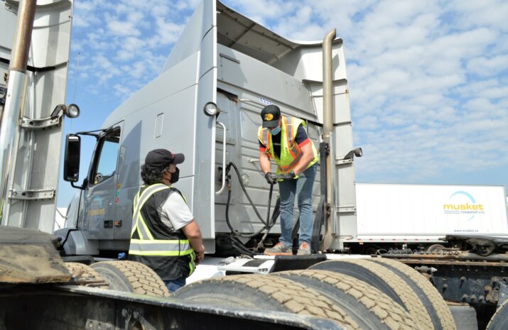 A student performs a pre-trip inspection on a truck
