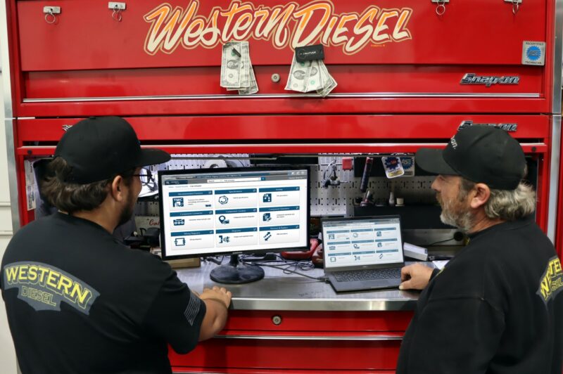 Technicians look at screens in a shop.