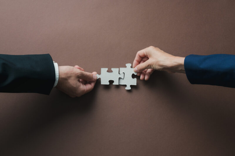 Pictures of hands fitting puzzle pieces