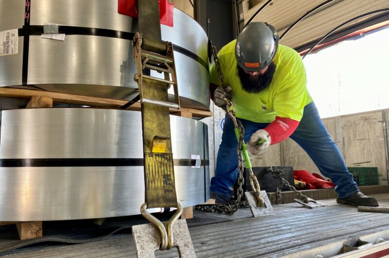 Picture of a driver securing a steel load.