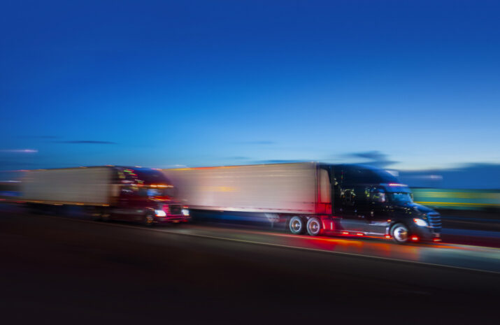 Two semi-truck sdriving on the highway at night - motion blur