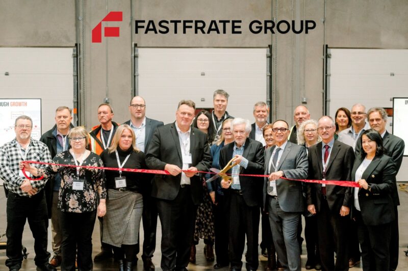 People standing inside a warehouse during a ribbon cutting ceremony
