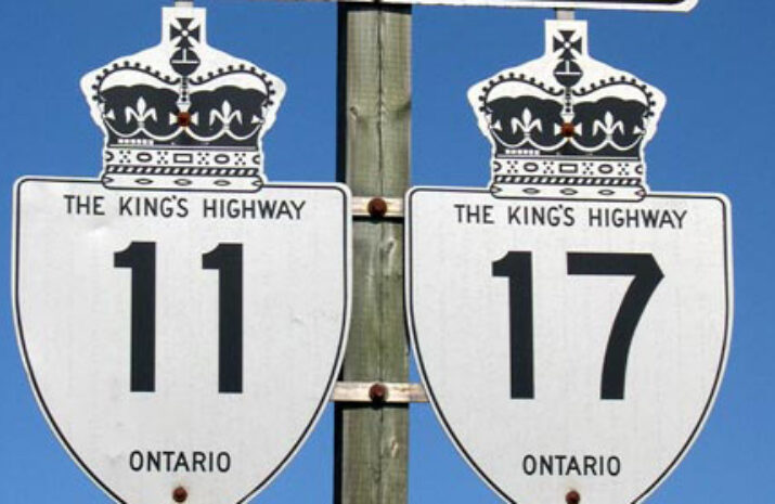 The image is of Highway 11 and 17 signs on a road in a Northern Ontario