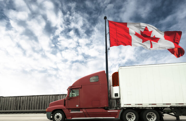 Truck on a highway with Canadian flag behind it