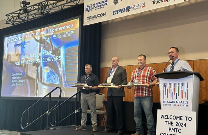 Four drivers standing on the stage with awards as they have been inducted into the Hall of Fame for Professional Drivers