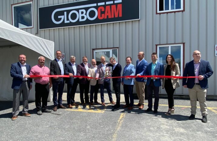 People cutting a ribbon in a yard