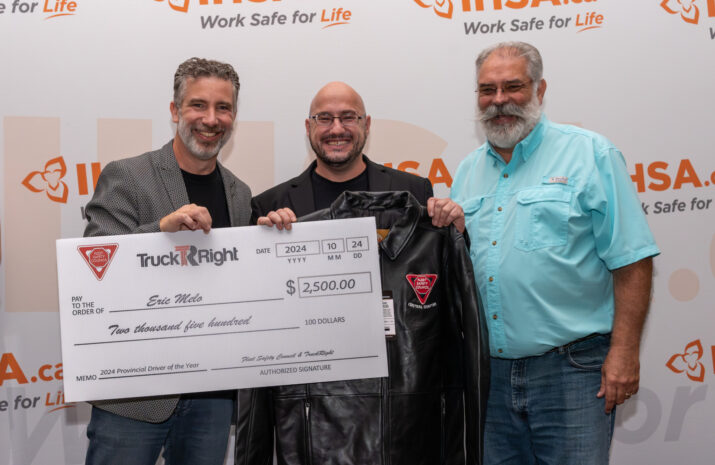 Eric Melo in the middle with Rick Brown and John Farquhar presenting him with a check