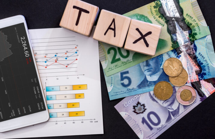 Taxation concept with canadian dollar, business graph and phone