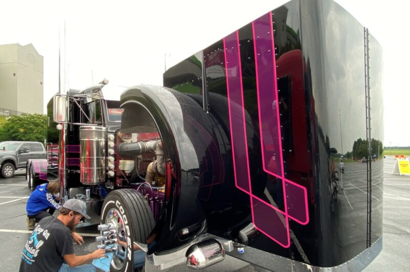 Picture of two people cleaning a truck's wheels