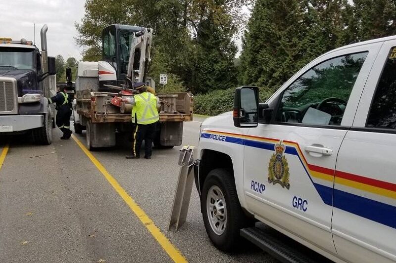 Officer inspecting trucks by the side of the road